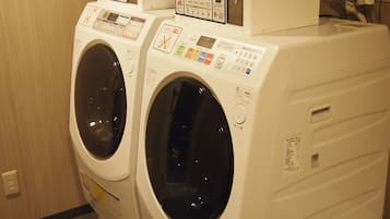 A row of front-loading washing machines in a hotel room.