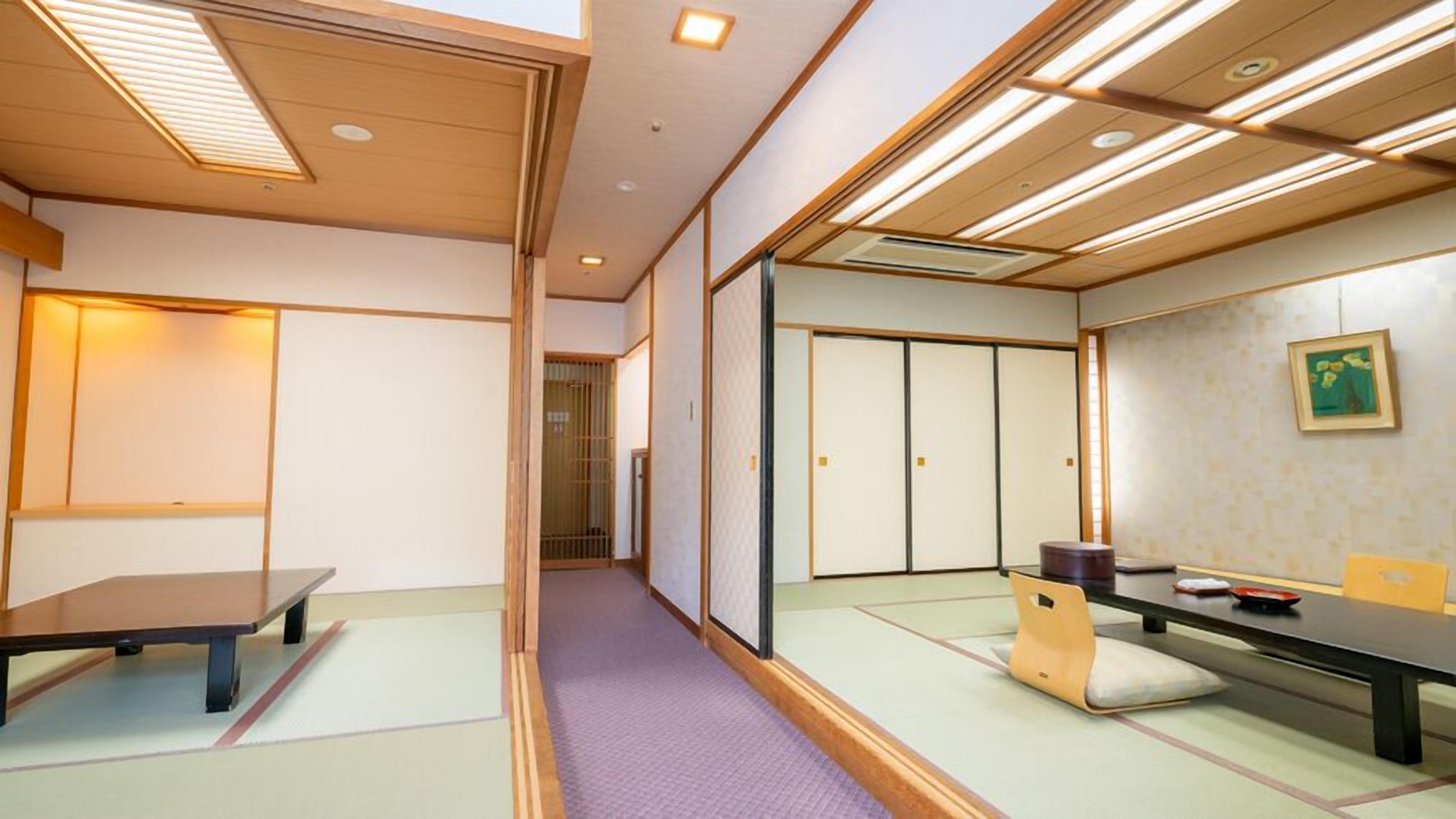 A traditional Japanese room with tatami flooring, sliding doors, a low table, and a cushion.