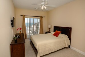 Ein Schlafzimmer mit Bett, Schreibtisch, Stuhl, Lampe und Blick aufs Meer.