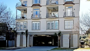 A multi-story residential building with balconies, a garage entrance, and a clear sky. - Tuscan Ocean Vista B Holiday Home Holiday home 8 (Myrtle Beach)