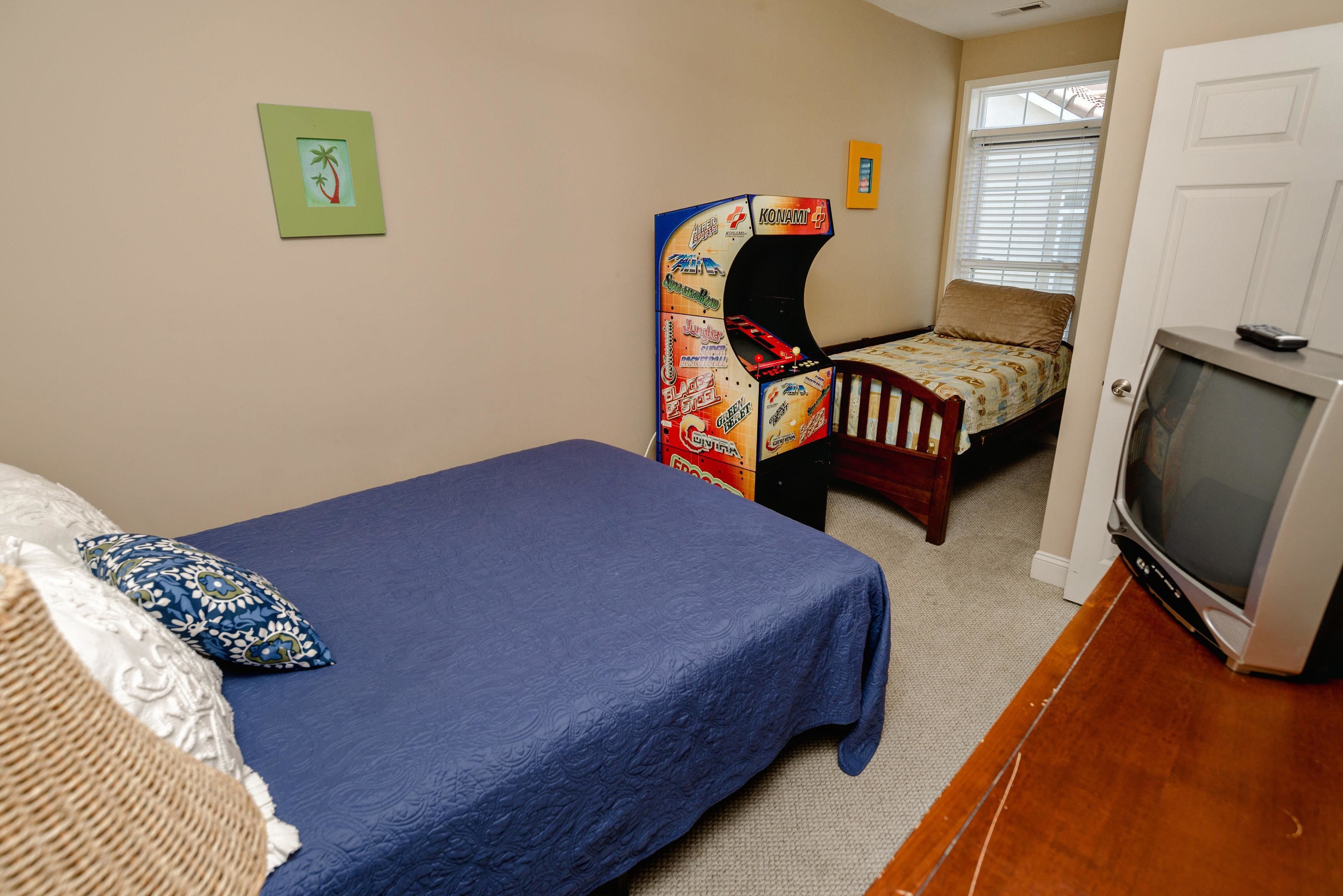 Une chambre avec un lit simple, une chaise, une télévision et une petite table.