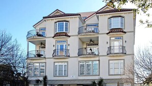 Un edifici residencial de diverses plantes amb balcons, un garatge i un cel serè.