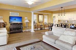 Relax in this stylish living room with a flat-screen TV, comfortable sofa, and dining area.
