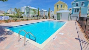 A swimming pool with a metal ladder, surrounded by a brick patio. - South Beach Cottages - 2701 Apartment 4 (Myrtle Beach)