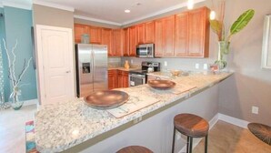 A modern kitchen with granite countertops, stainless steel appliances, and wooden cabinets. - South Beach Cottages - 2716 Apartment 3 (Myrtle Beach)