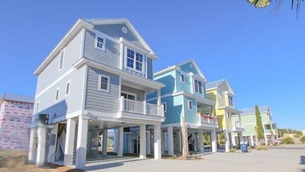 A row of beach houses with balconies, a clear sky, and a paved driveway. - South Beach Cottages - 2716 Apartment 3 (Myrtle Beach)