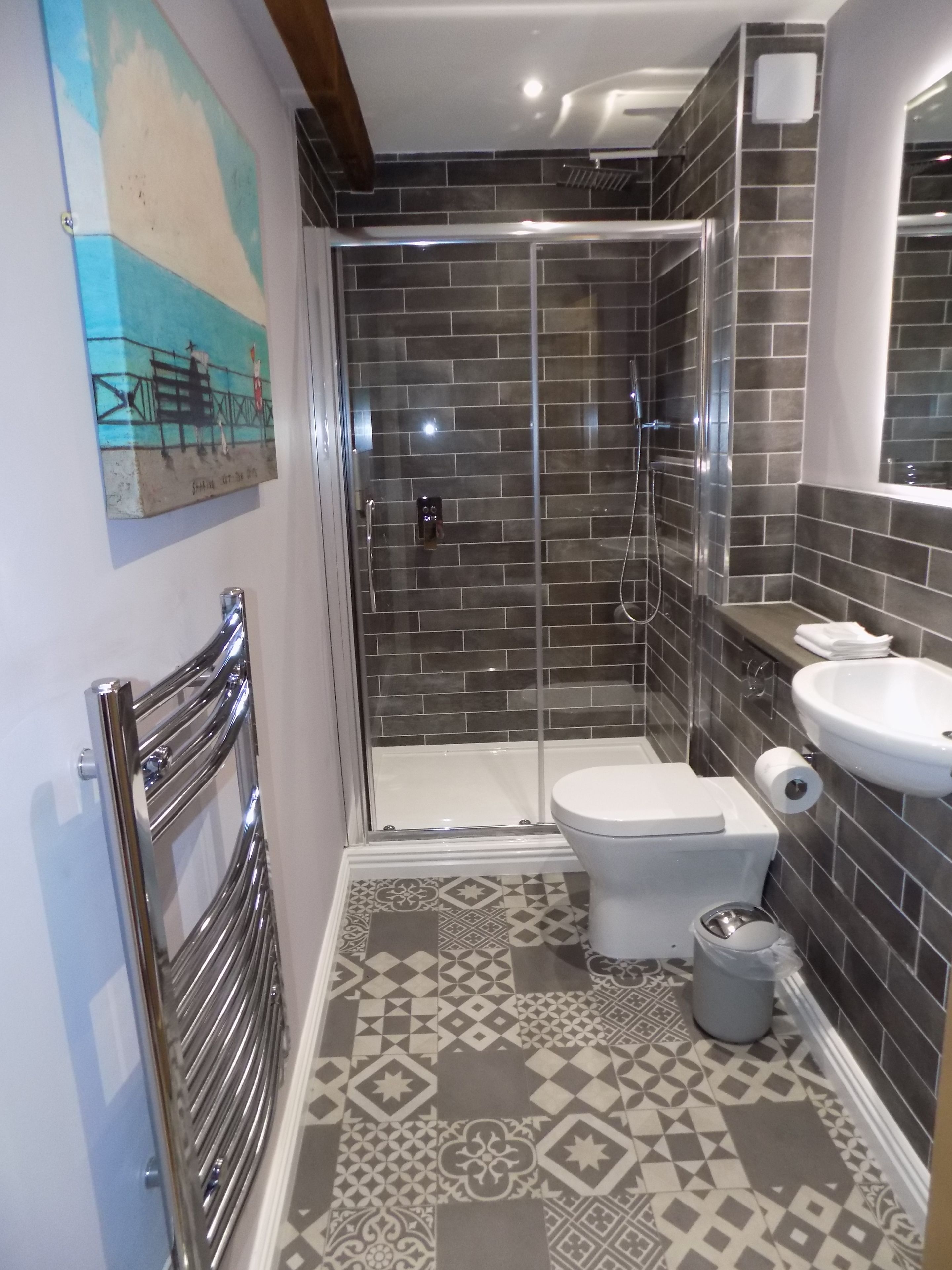 A bathroom with a shower, toilet, and sink.