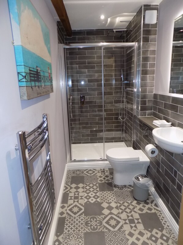 Un baño con ducha, inodoro y lavabo.