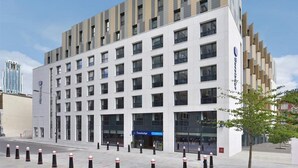 Ein modernes Hotel mit weißer Fassade und mehreren Etagen.