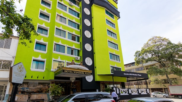 A multi-story hotel with a bright green facade, multiple windows, and a sign indicating it is the Windsor Plaza Hotel. - Hotel Windsor Plaza (Cali)