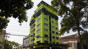 A multi-story building with a green facade, multiple windows, and a visible entrance. - Hotel Windsor Plaza (Cali)