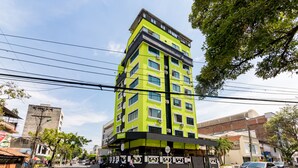 A multi-story building with a bright green facade, large windows, and a visible restaurant sign. - Hotel Windsor Plaza (Cali)