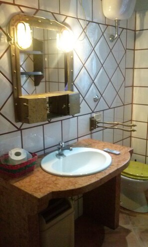 A bathroom with a sink, mirror, and toilet. - Aurelio Rapillo (Latina)