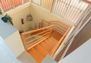 Una escalera con barandas naranjas y un papel tapiz con diseño.