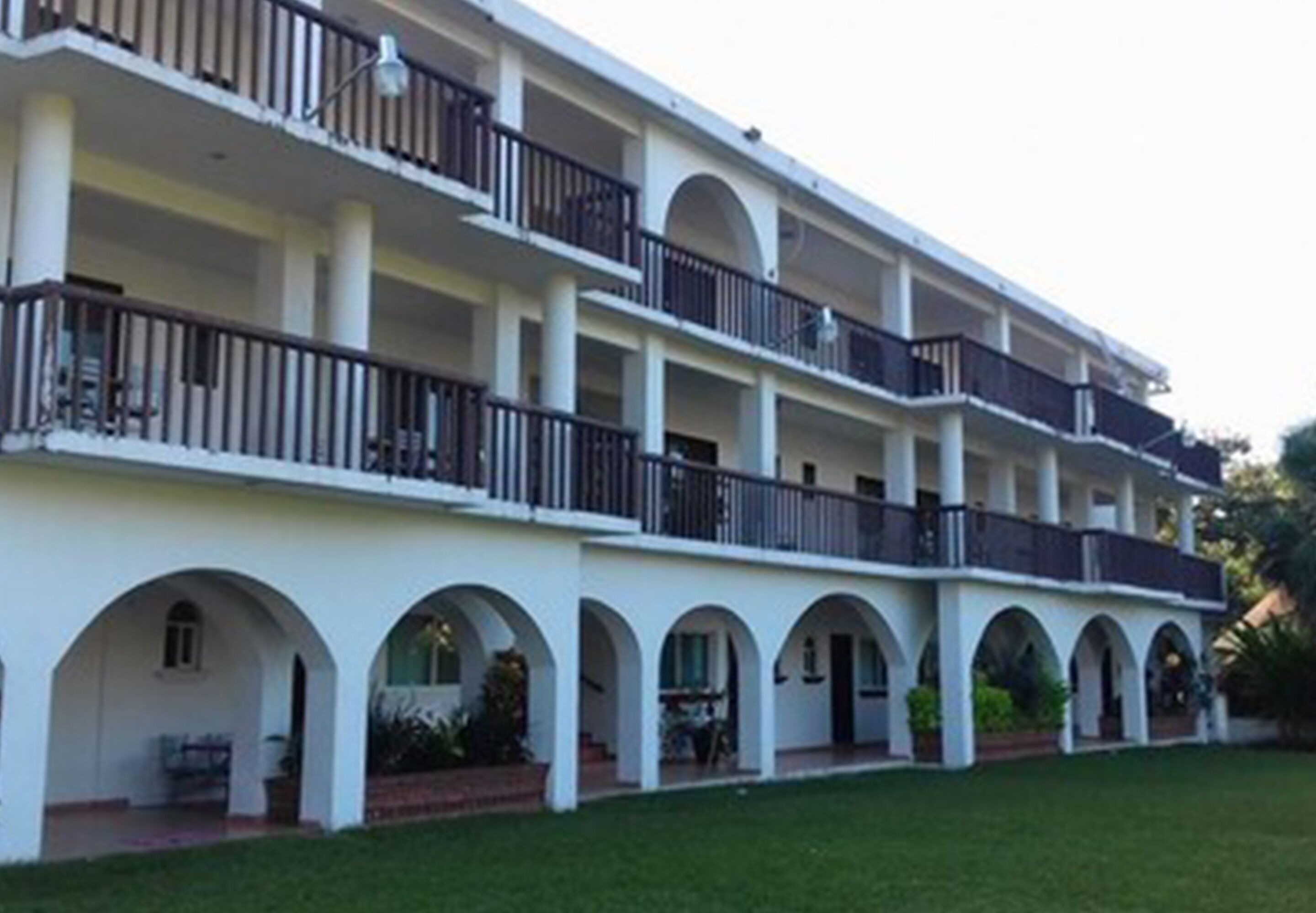 A multi-story hotel with a central courtyard, balconies, and arched walkways.