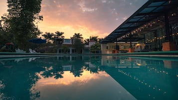 Una piscina al aire libre, sillones reclinables de piscina