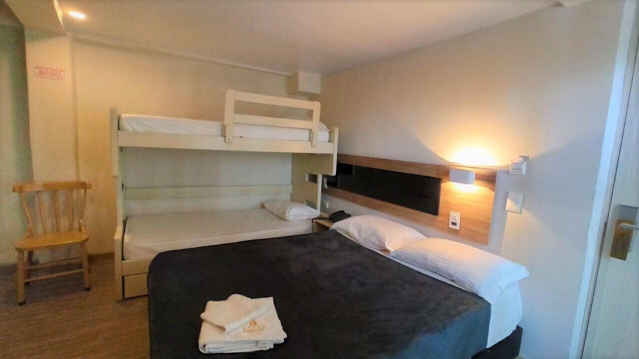 Una habitación con literas, un escritorio y una silla.