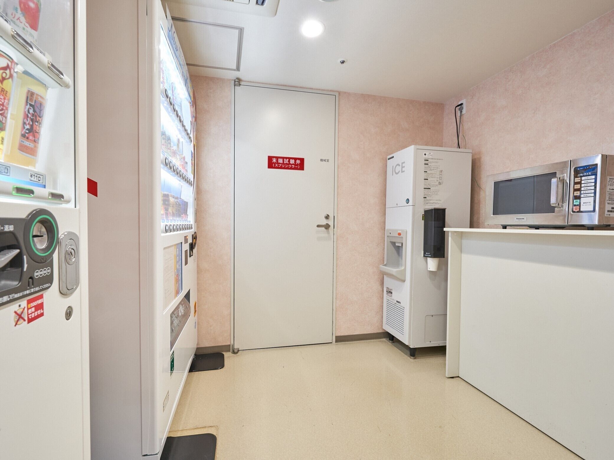 A hotel room with a vending machine, a microwave, and a water dispenser.
