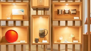 A display of various ceramic items in a well-lit, wooden-framed exhibit.