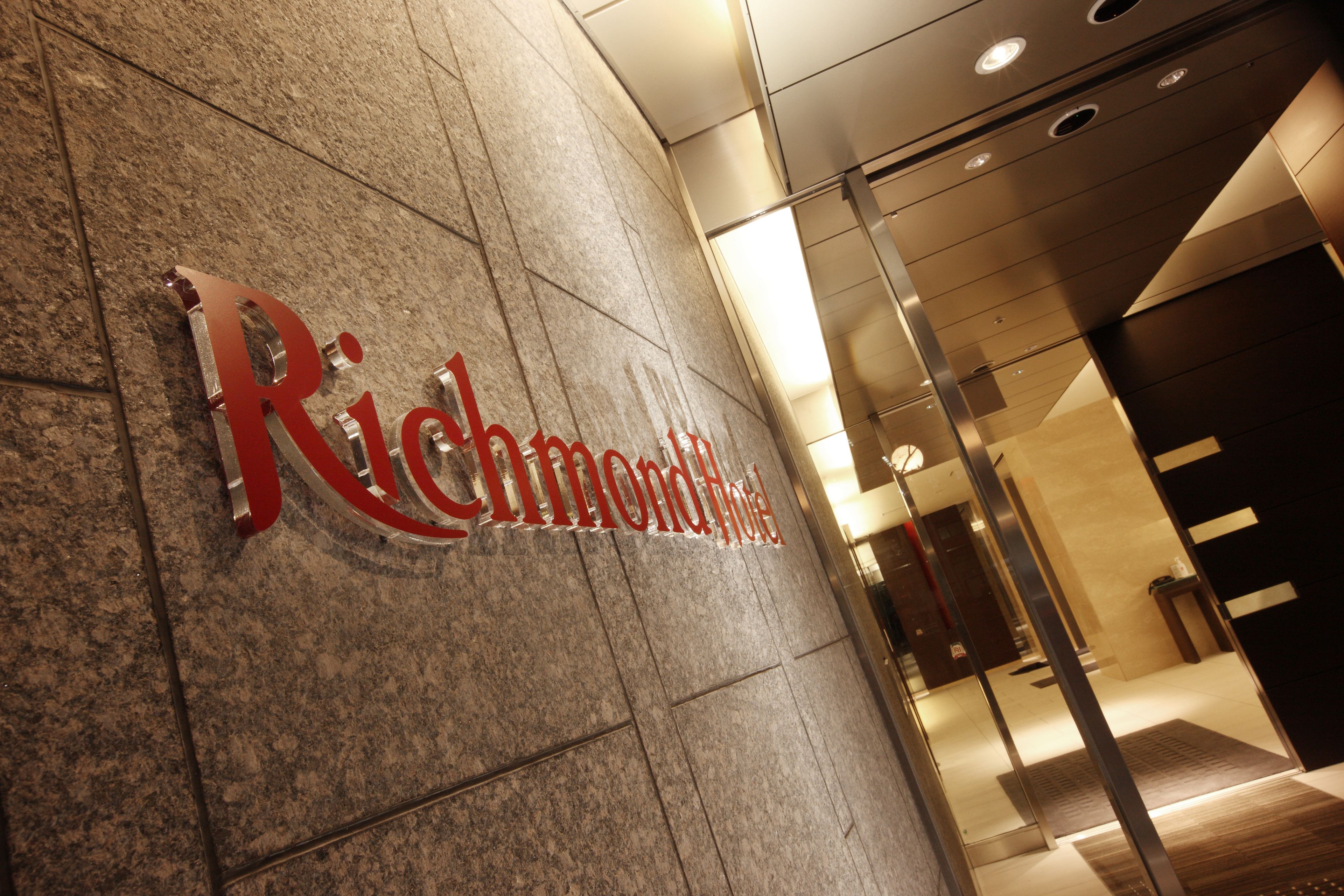 A stone wall with the words "Richmond Hotel" in large, metallic letters.