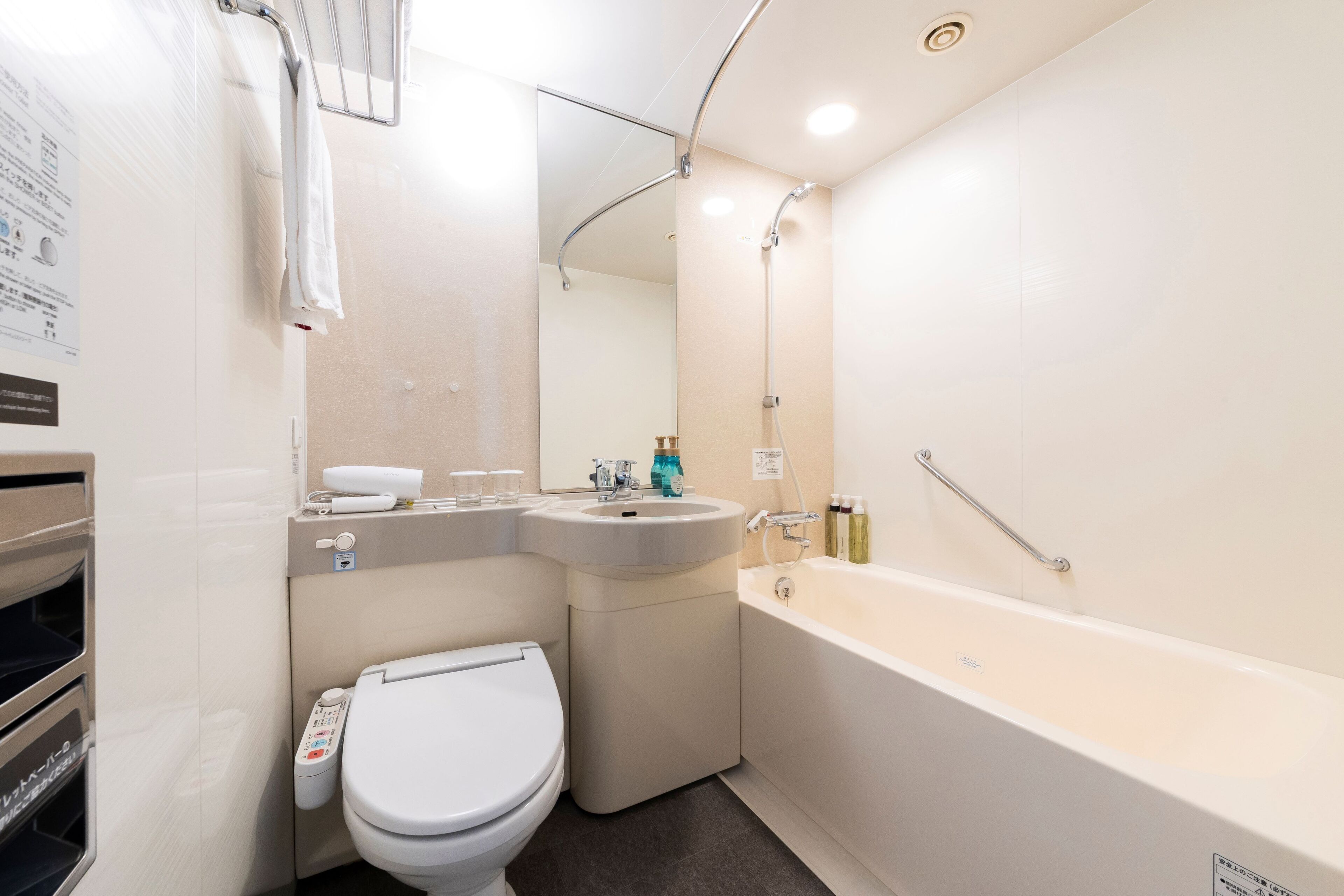 A modern bathroom with a toilet, sink, and bathtub.