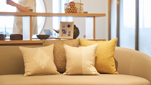 A living room with a sofa, decorative pillows, a coffee table, and a mirror.