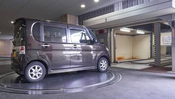 A compact car parked inside a building with a ramp leading to a garage.