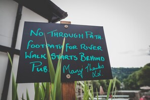 A sign with handwritten text indicating a no through path and a footpath for a river walk starting behind a pub. - Ye Old Ferrie Inn (Ross-on-Wye)