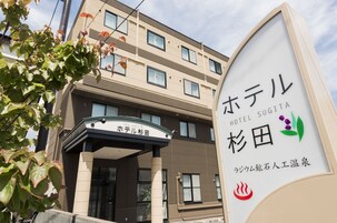 Una entrada de hotel con señalización en japonés, que indica que es el Hotel Sugita.