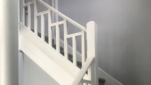 A staircase with white railings and carpeted steps. - Roe Summer Cottage, Suite B (Watkins Glen)