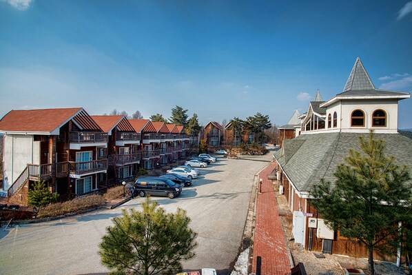 Une rangée de maisons de ville avec un parking devant.