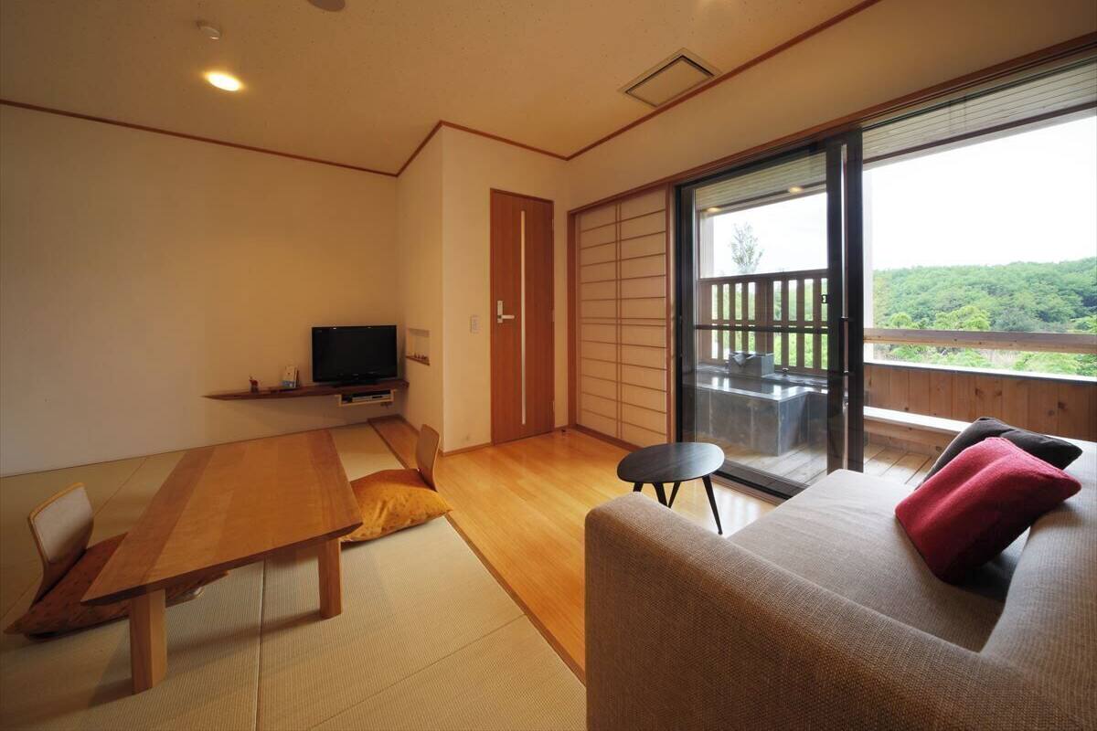 Una habitación con una mesa de madera, un sofá y un televisor.