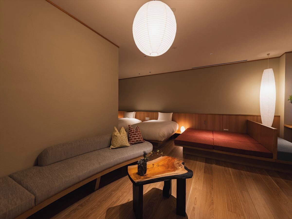 Ein modernes Interieur mit einer Couch, einem Holztisch und einer Pendelleuchte.