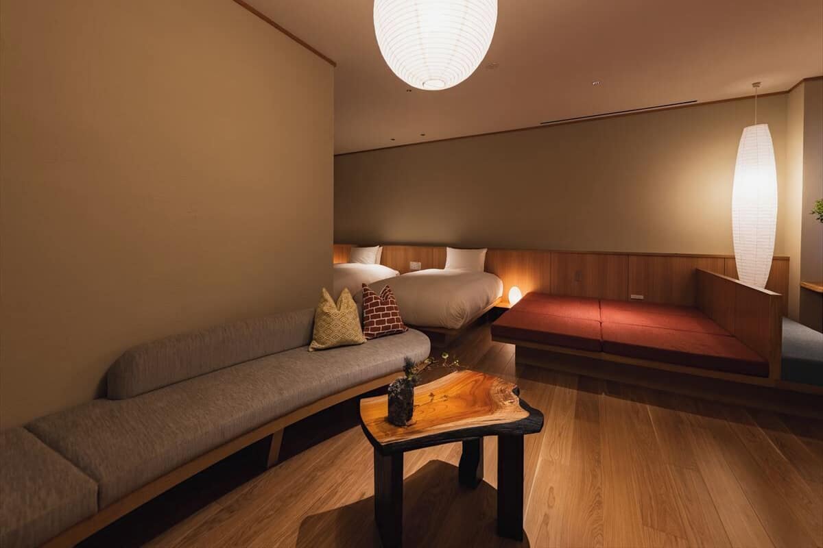 Un interior moderno con un sofá, una mesa de centro de madera y un lámpara colgante.