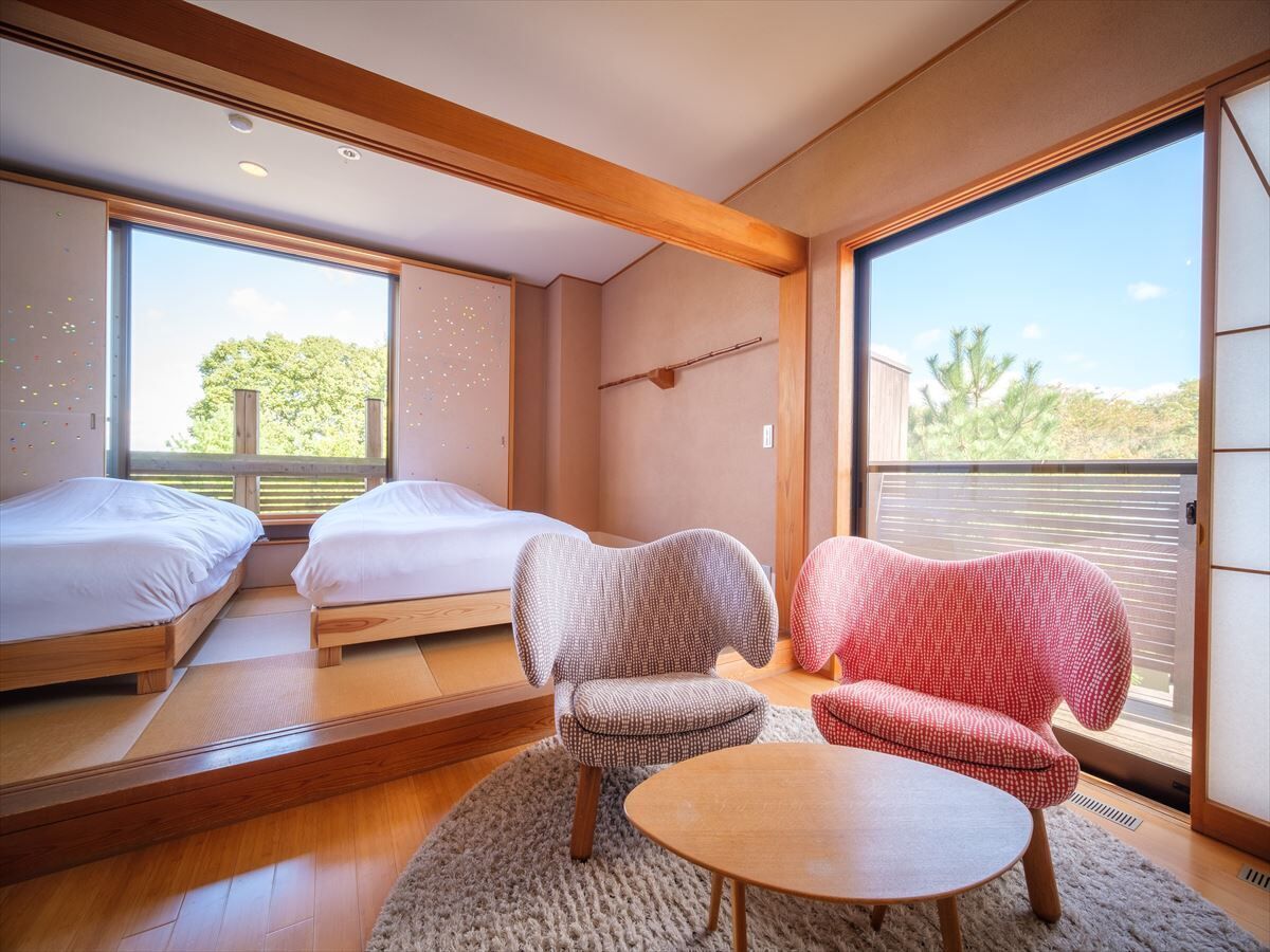 Ein modernes Zimmer mit zwei Betten, einem Sofa und einem Tisch.