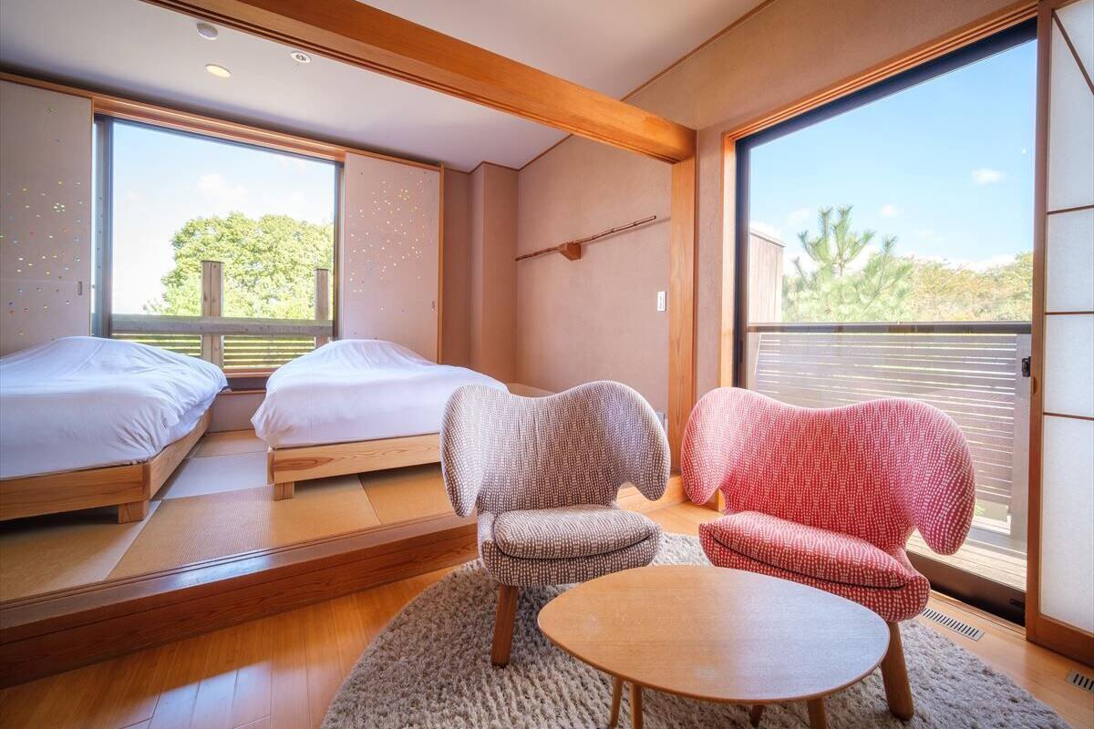 Una habitación moderna con dos camas, un sofá y una mesa.