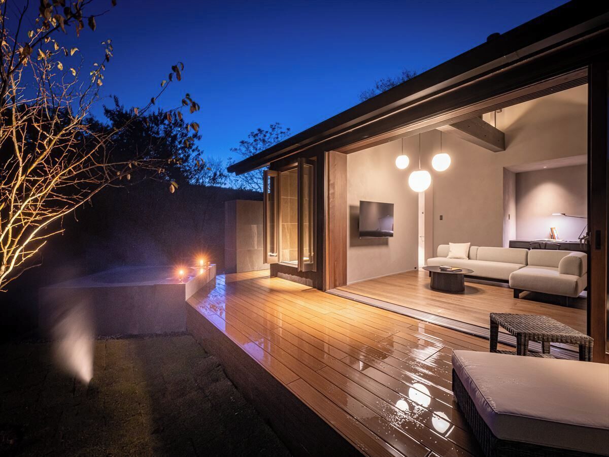 Ein modernes Haus mit einer Holzterrasse, einem Sofa und einem Fernseher im Wohnbereich.