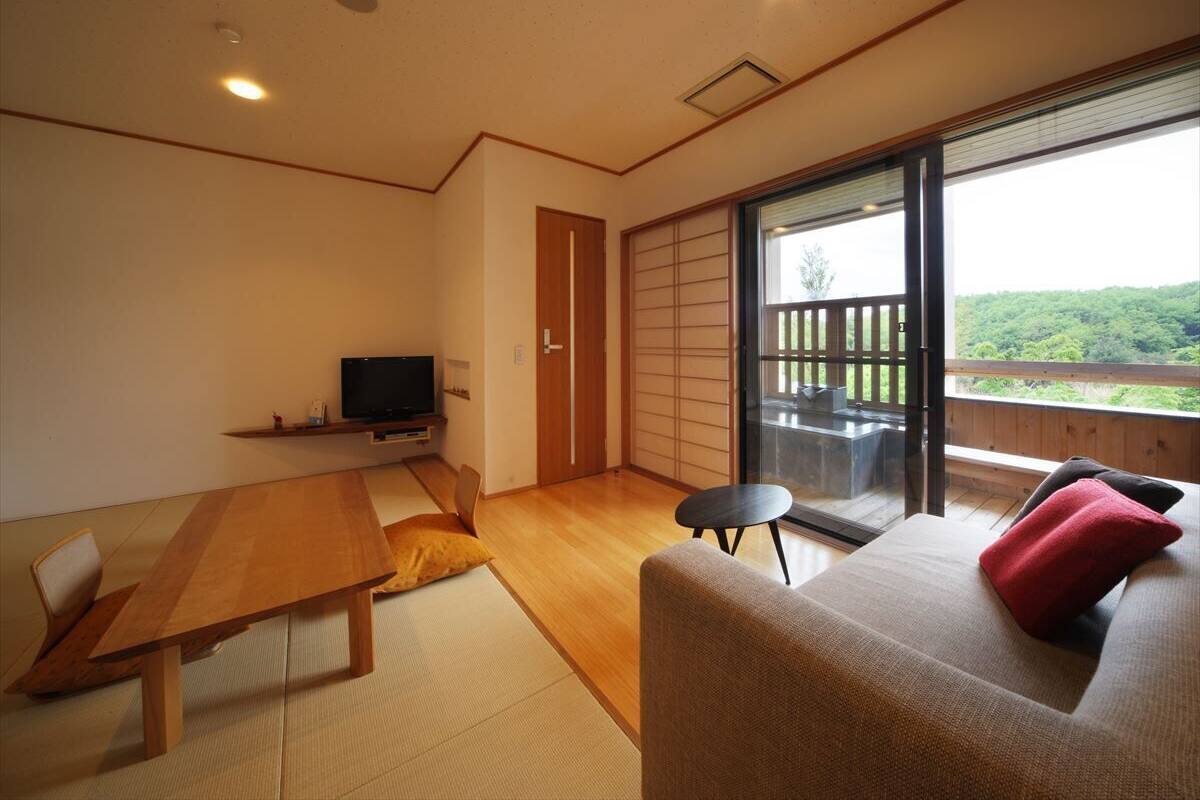 Un interior moderno con una mesa de madera, sofá y televisor.