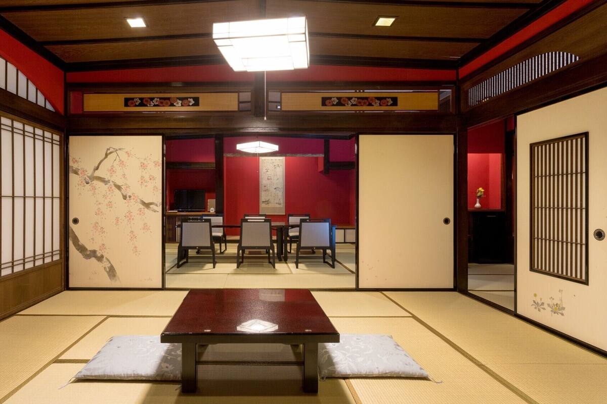 Una habitación japonesa tradicional con suelo de tatami, una mesa baja y paneles shoji.