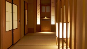 A traditional Japanese hallway with sliding doors and a central light fixture.