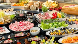 Un buffet proposant une variété de plats, notamment des fruits de mer, des légumes et des desserts.