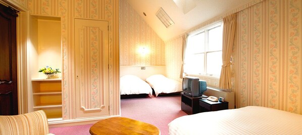 A hotel room with a bed, a desk with a television, a small table, and a window with curtains. - Hotel Green Plaza Tojoko (Kato)