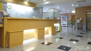 Zona de recepción con mostrador, asientos y máquina expendedora.