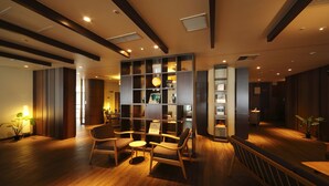 A modern interior with wooden flooring, built-in shelving, and seating areas. - Ooedo Onsen Monogatari Hotel Reoma no Mori (Marugame)