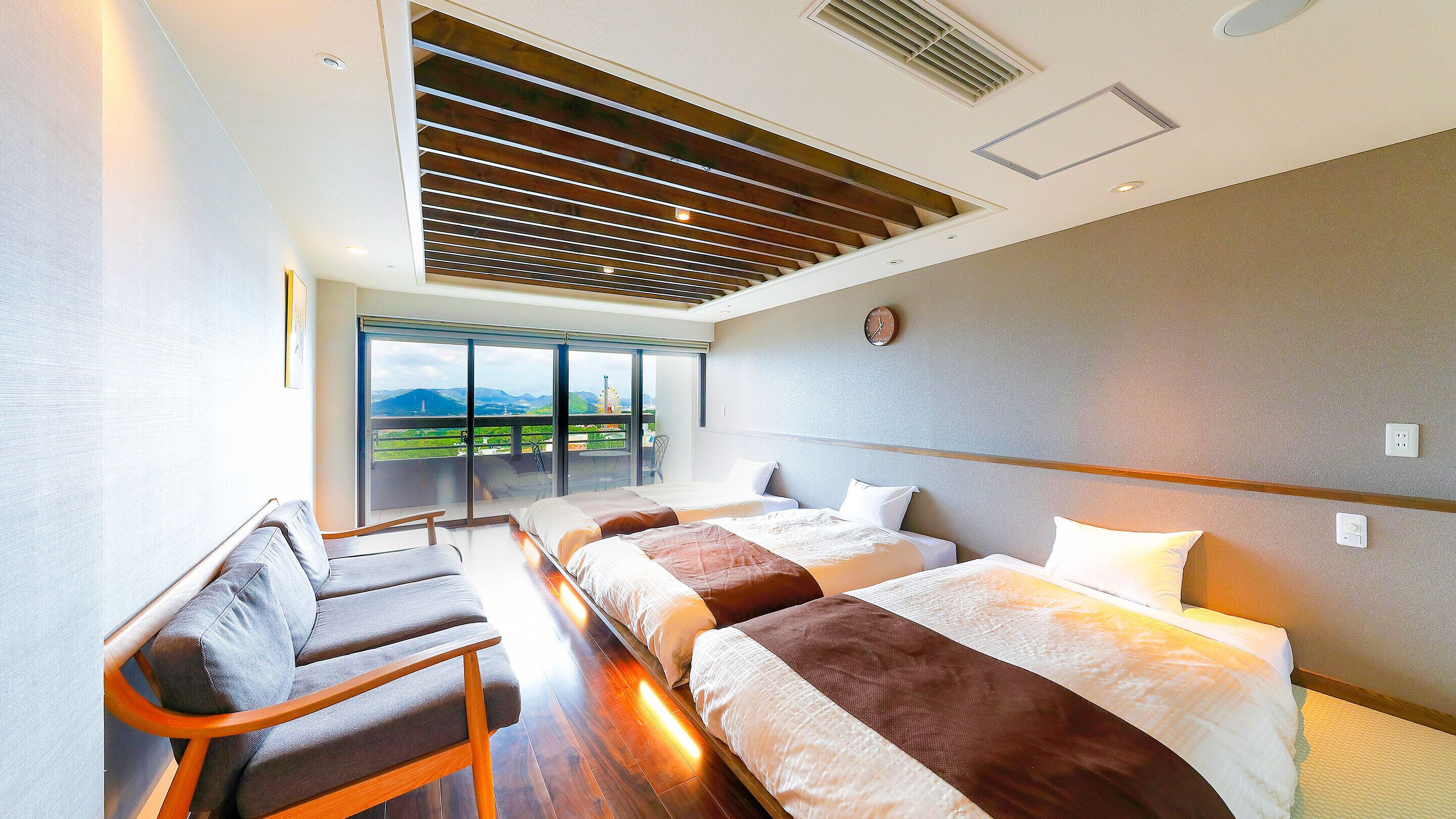 A hotel room with a large window, two beds, a chair, and a ceiling with wooden slats.