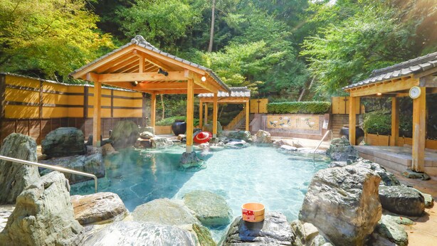 A traditional Japanese onsen with wooden structures, a clear hot spring, and large rocks. - Ooedo Onsen Monogatari Hotel Reoma no Mori (Marugame)