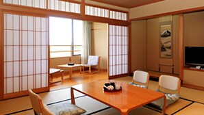 A traditional Japanese-style room with tatami flooring, a low wooden table, and shoji screens. - Ikoi no Mura Noto Hanto (Shika)