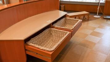 A wooden bench with two woven baskets underneath.