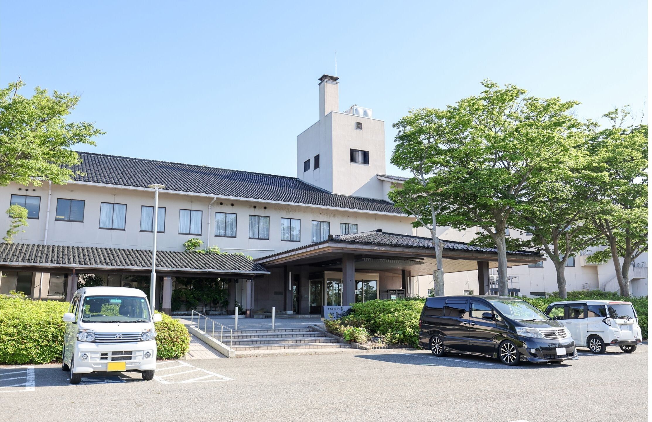 A hotel with a modern design, featuring a prominent tower and a covered entrance.