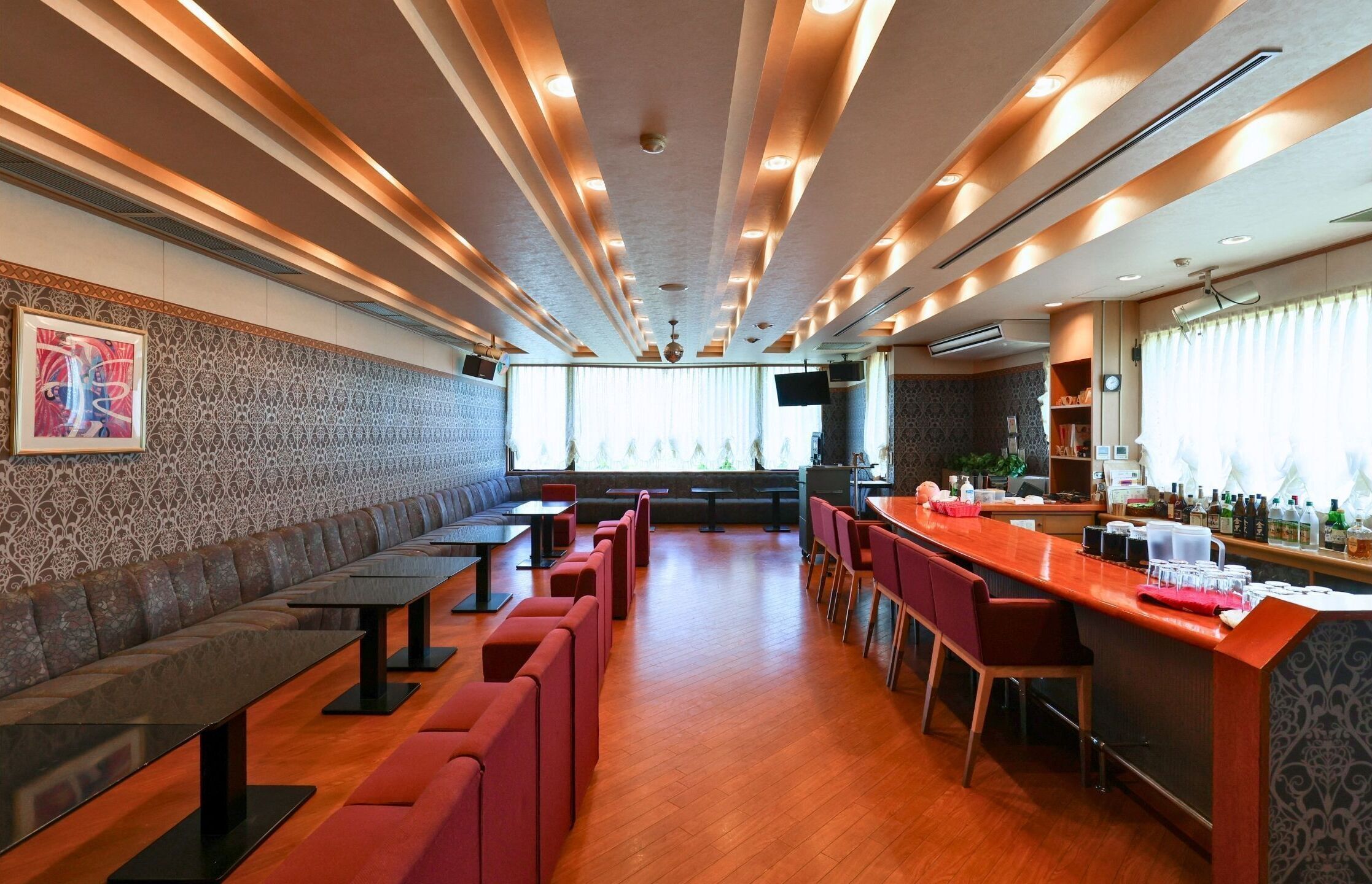Een modern restaurant met een lange toonbank, zitjes en een bar.